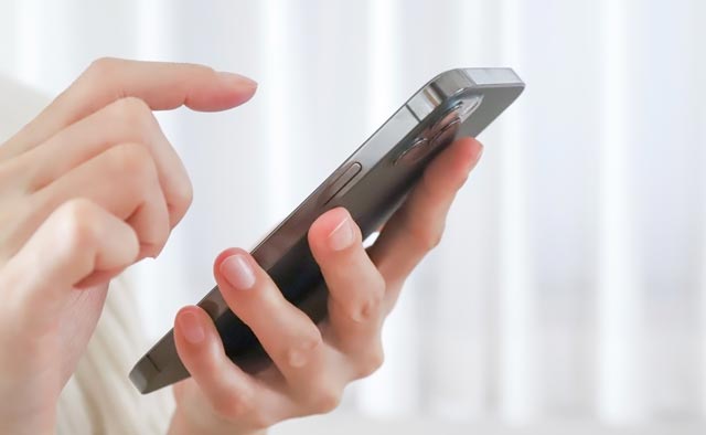 家族葬の府中市葬儀社に電話でお問合せしようとしている人の手元。